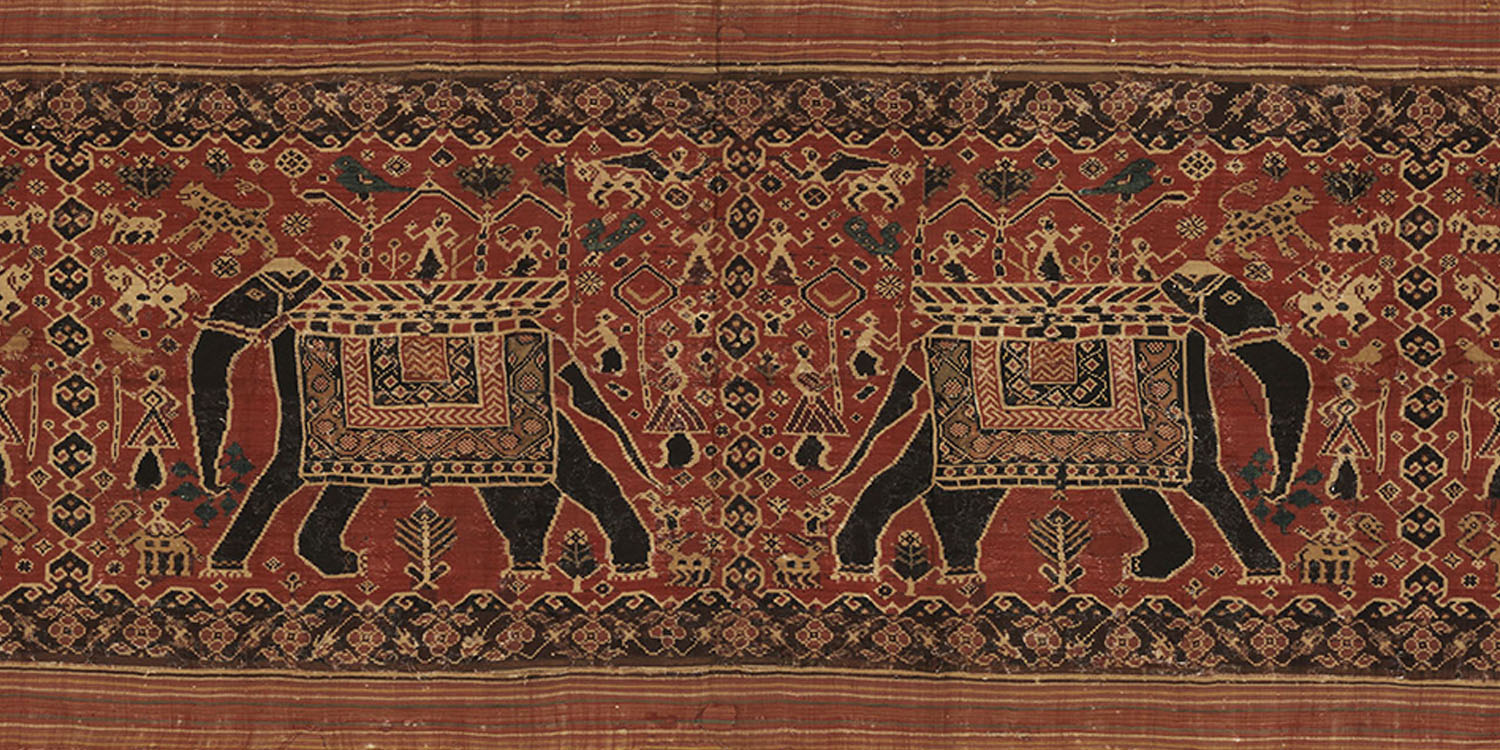 A Patan Patola textile with a pattern of two pairs of elephants on the body and floral and triangle motifs on the border.