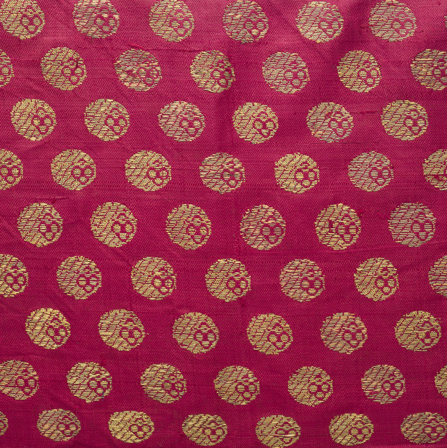 Multiple coin-shaped ashrafi motifs made of gold brocade on a piece of textile