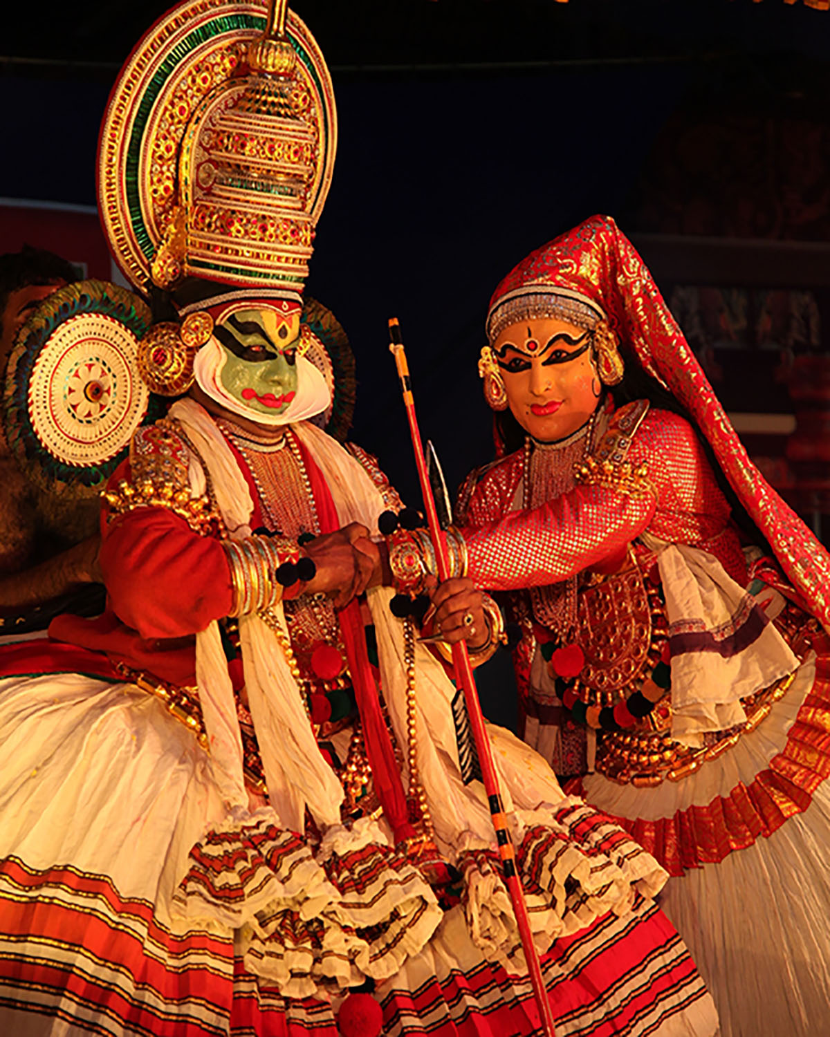 A pair of Kathakali dancers wearing the costume of a male and a female character respectively.