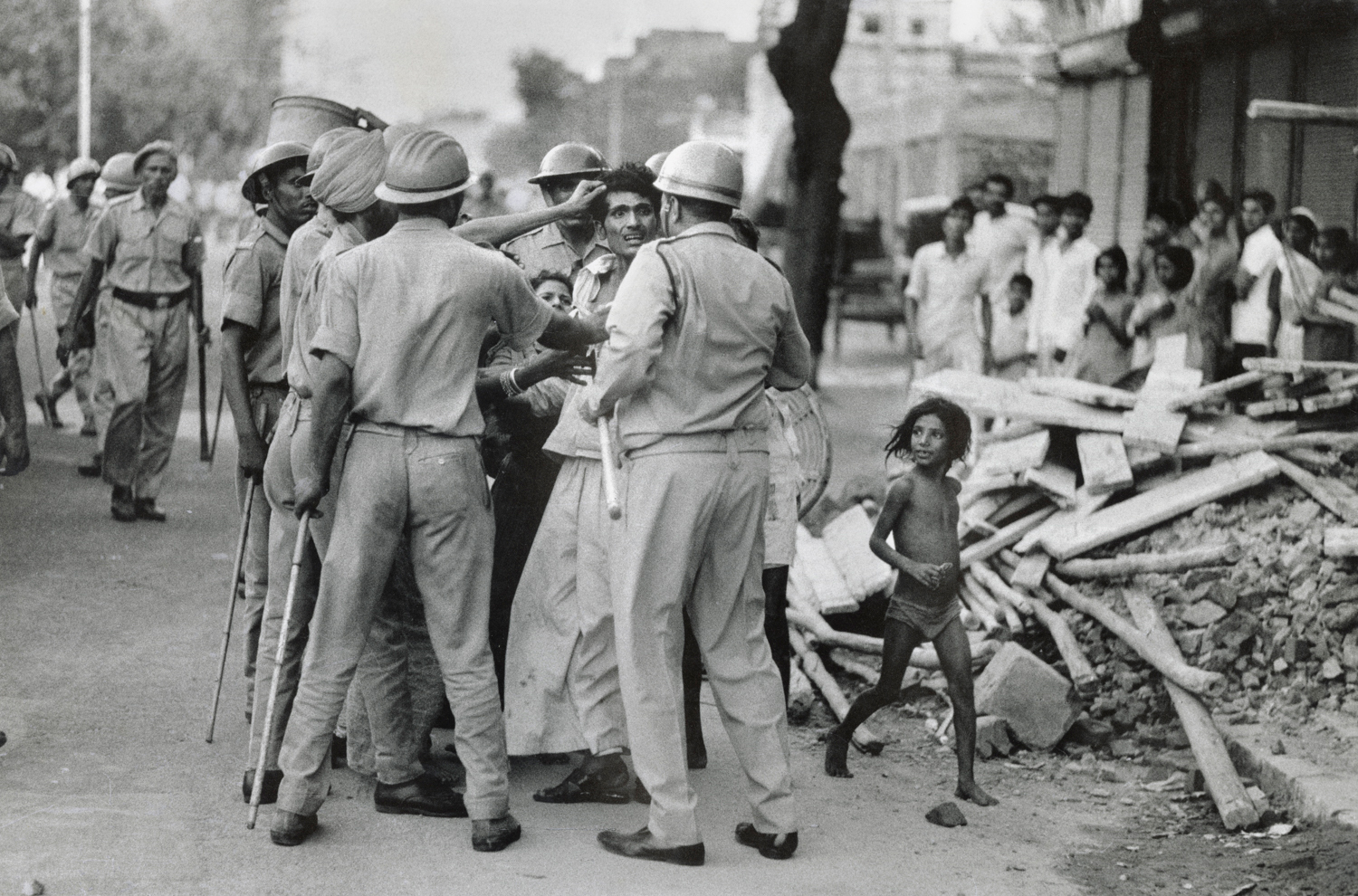 Archival photograph by Raghu Rai of policemen surrounding a man during a protest in Delhi