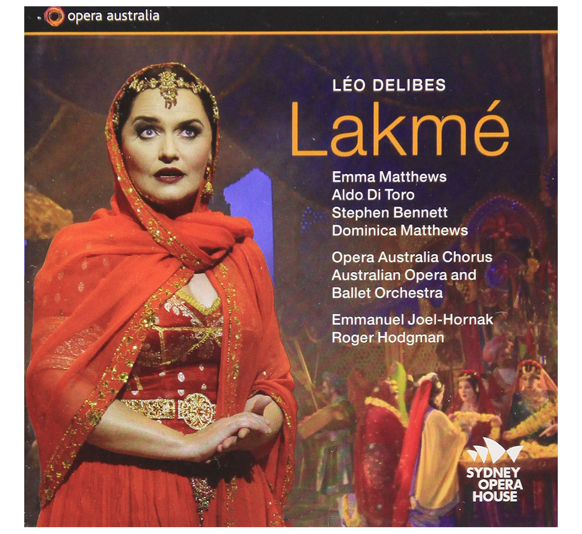 Poster of opera "Lakme" depicting a woman in a red ghagra-choli, dupatta drawn over her head, at the forefront with other characters in colourful attire in the background. The names of actors and artists are set to the right of the woman.