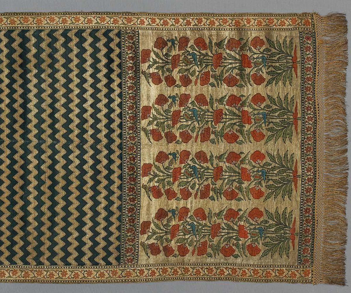 Photograph (detail) of Mughal-era dark blue silk patka with brocade patterns of plants, birds and chevrons on border and end panel