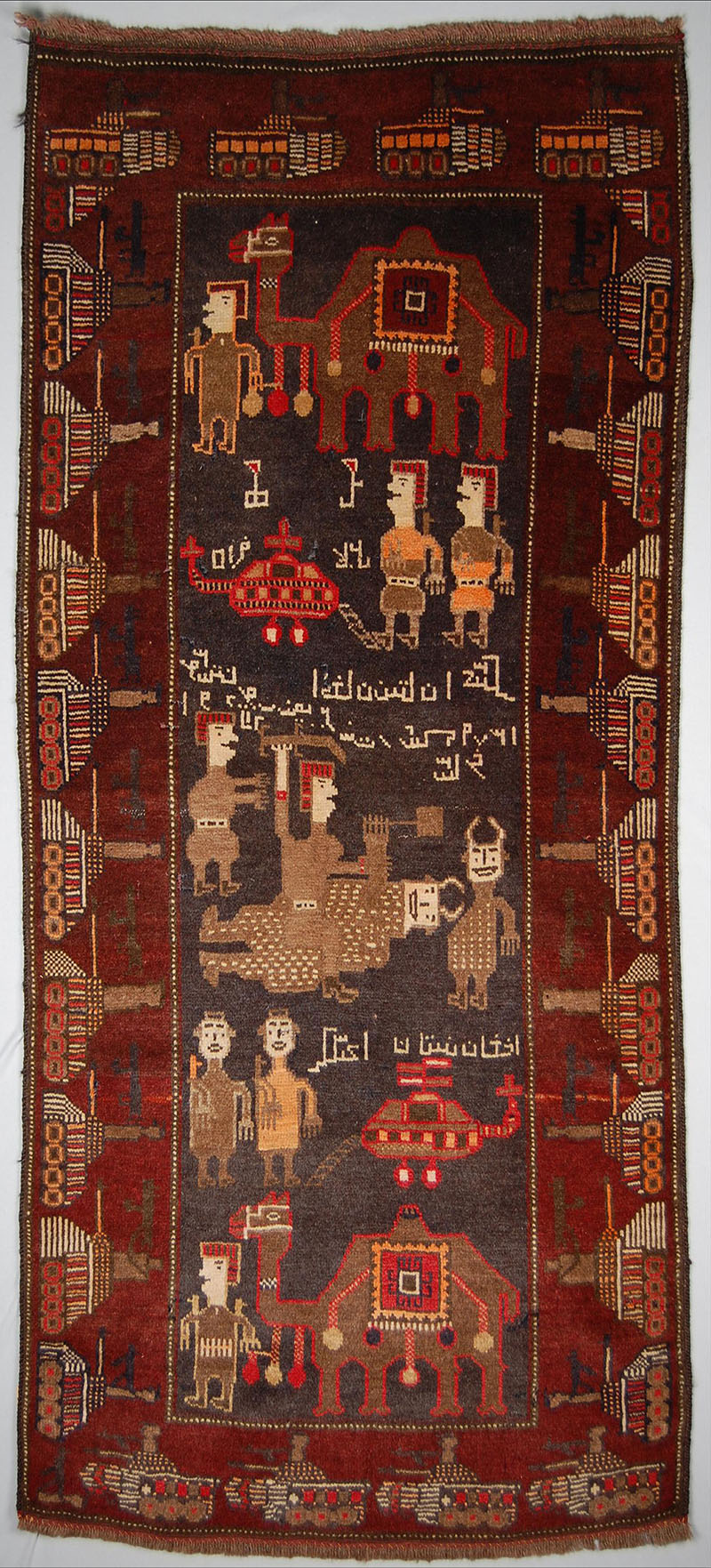 Afghan war rug depicting Afghan and Soviet soldiers, helicopters, camels against brown ground and deep red border with tank motifs
