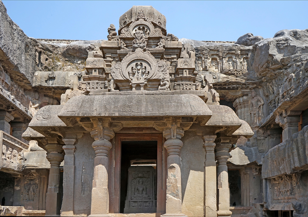 Photograph of a small Dravida-style shrine in the Indra Sabha, Ellora Cave 32, a carved tablet showing a seated figure seen in the sanctum
