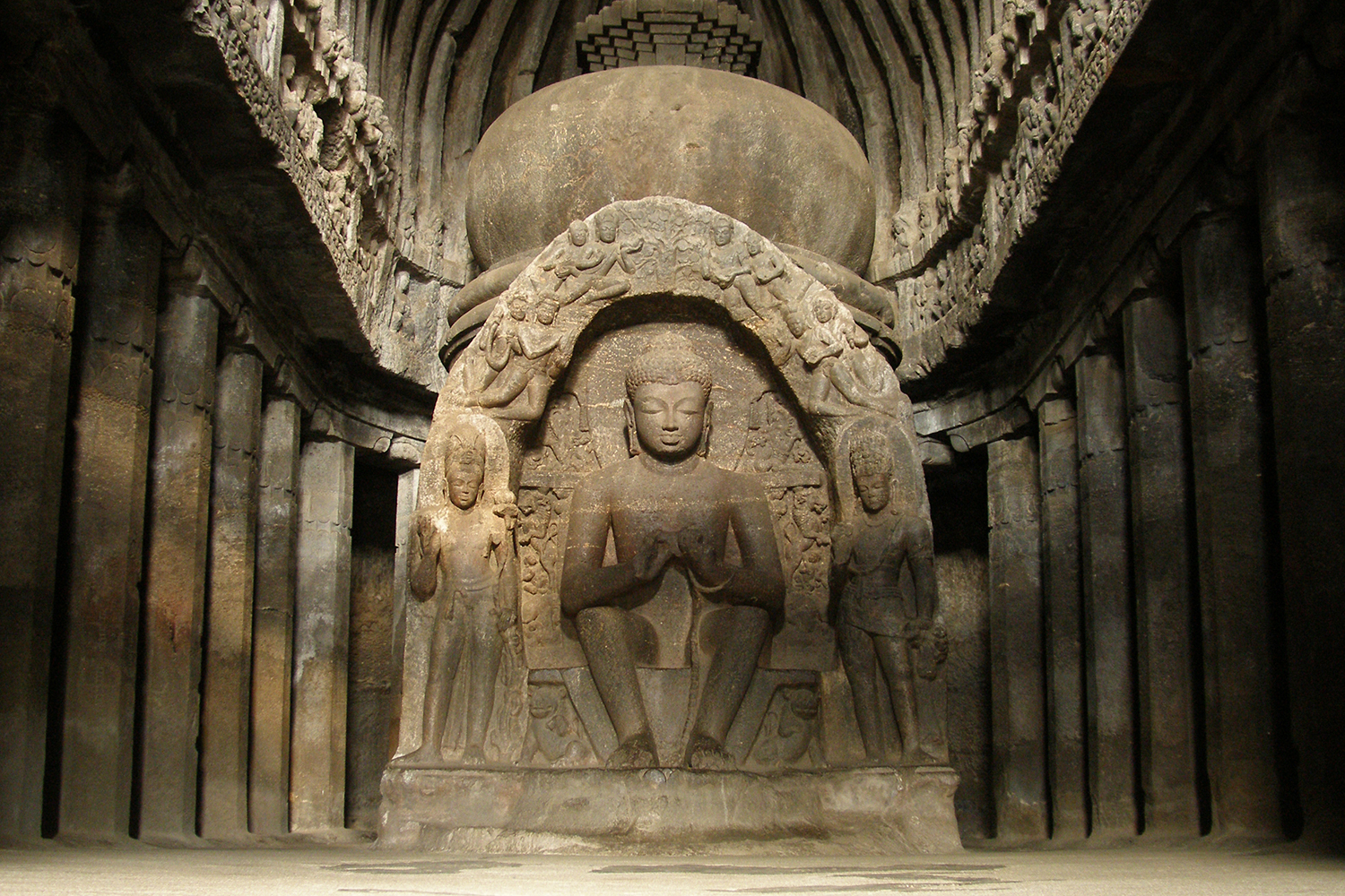 Photograph of relief sculpture at Ellora Cave 10 or Vishwakarma Cave showing seated Buddha in the Dharmachakra Mudra