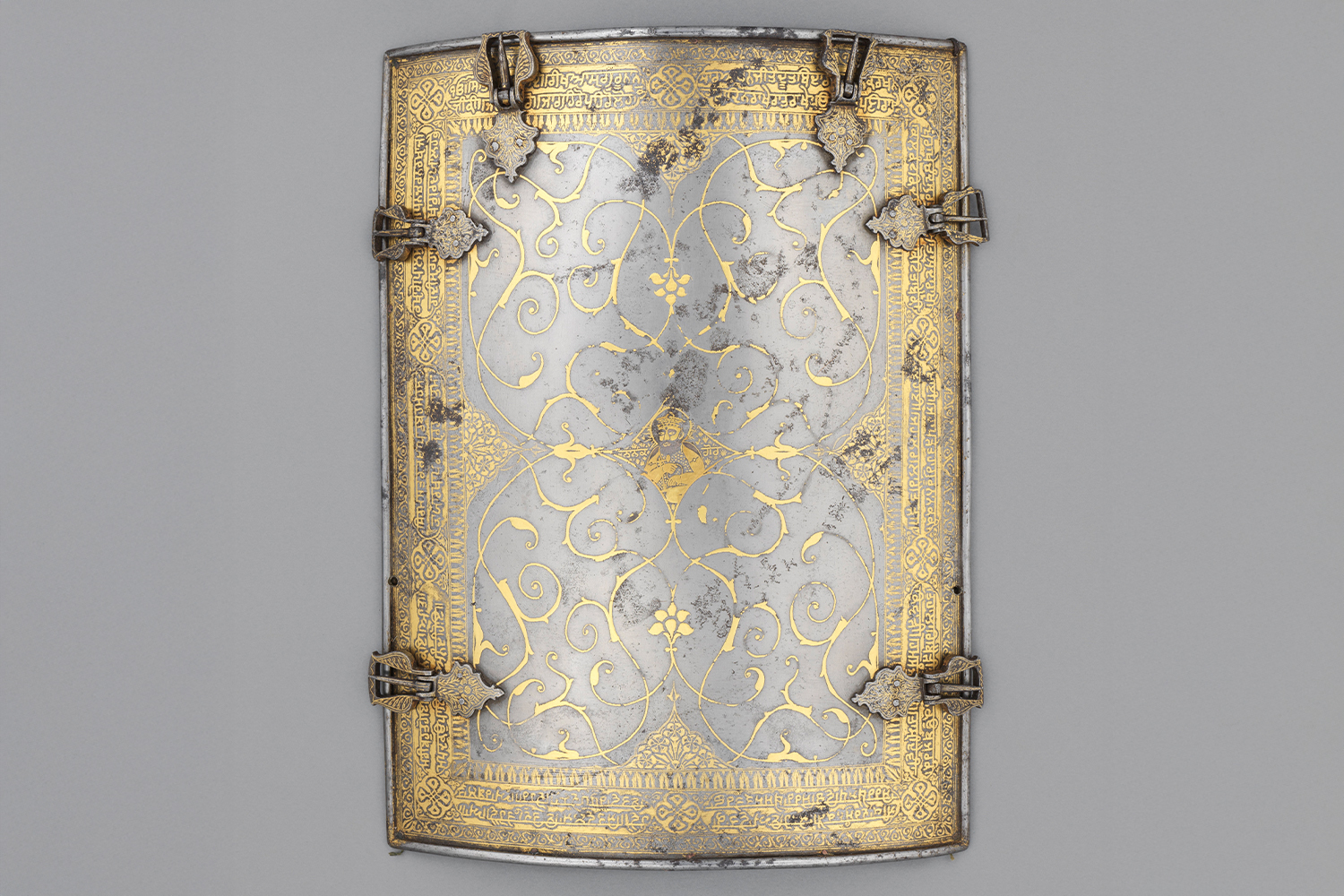 Photograph of one piece of steel or iron chahar-aina or four-piece cuirass with gold koftgari and a portrait of Guru Nanak in its centre