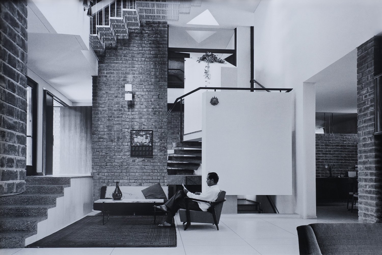 Archival print showing AP Kanvinde seated on a chair at his home by Madan Mahatta