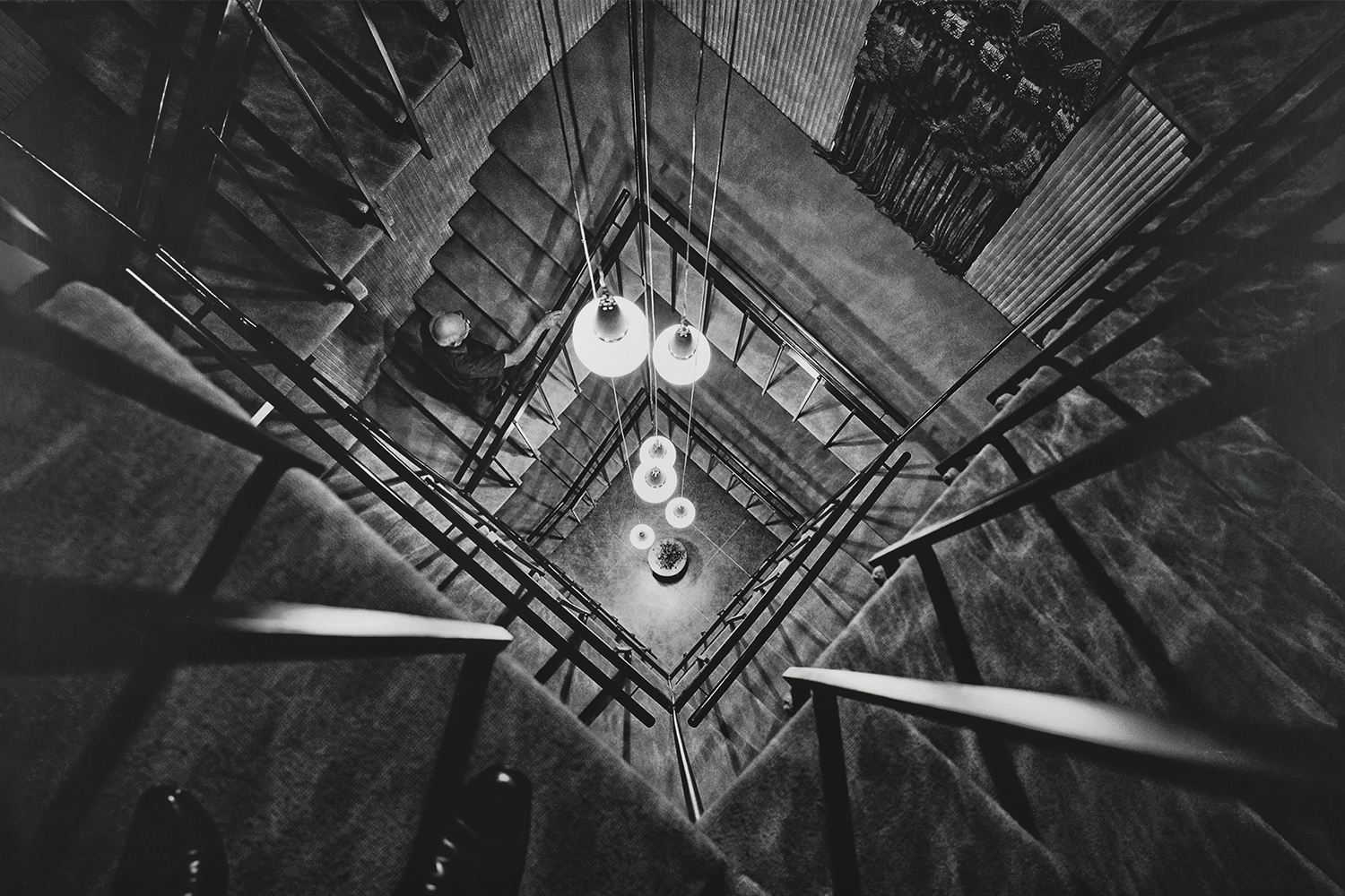 Archival print taken from the top showing architect Joseph Allen Stein walking up the staircase of the Ford Foundation office by Madan Mahatta