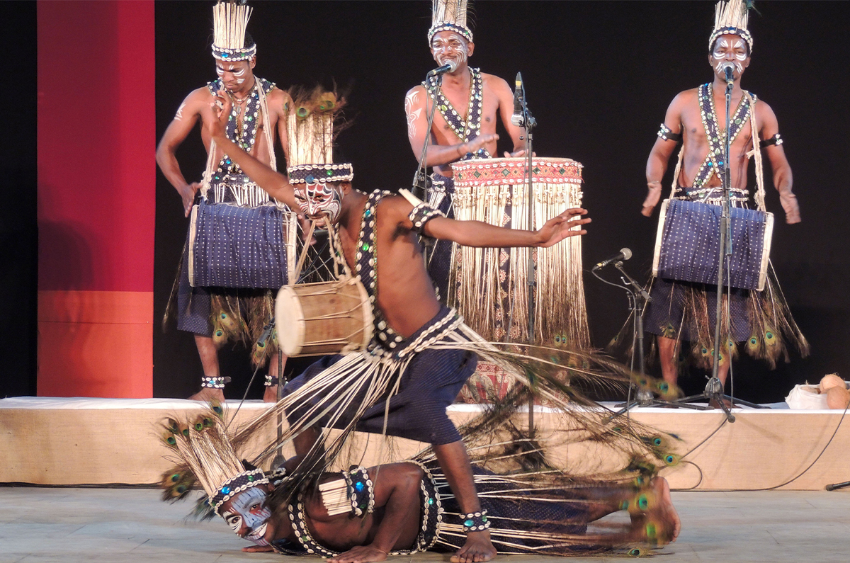 Photograph of a Siddi Dhamaal performance with three drummers behind two dancers