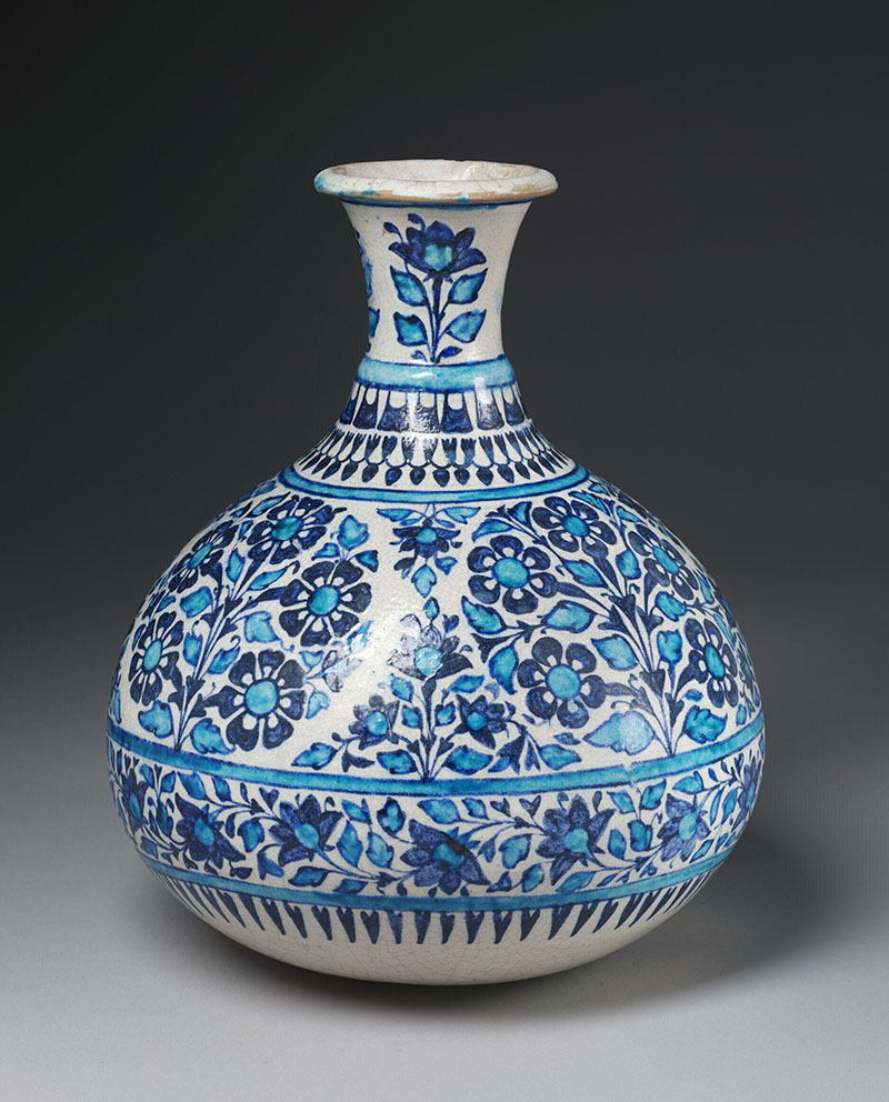 Photograph of a late-19th-century glazed ceramic vase with floral designs in blue over a white background