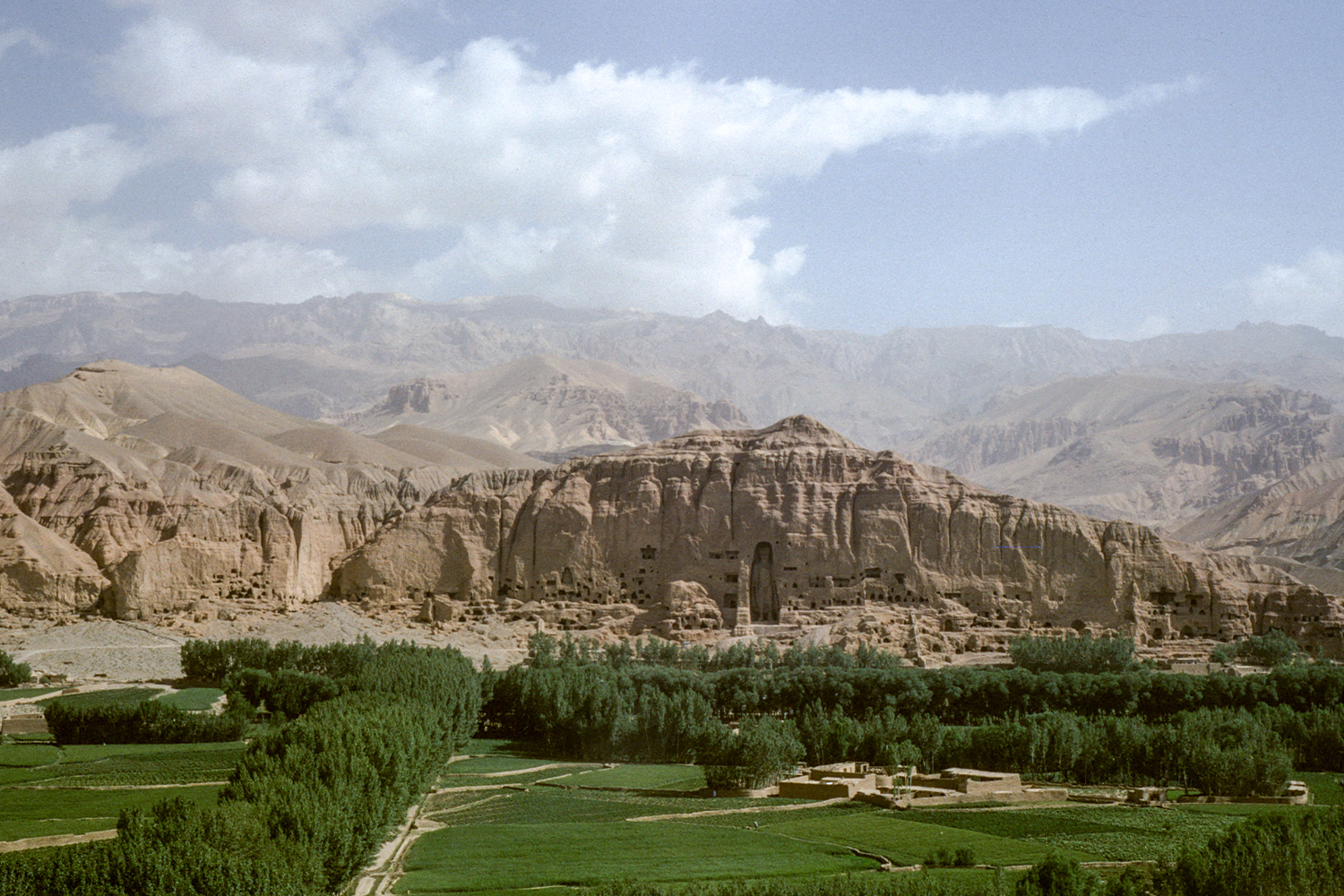 Archival photograph by Francoise Foliot showing a distant view of the cliff face with the eastern Bamiyan Buddha