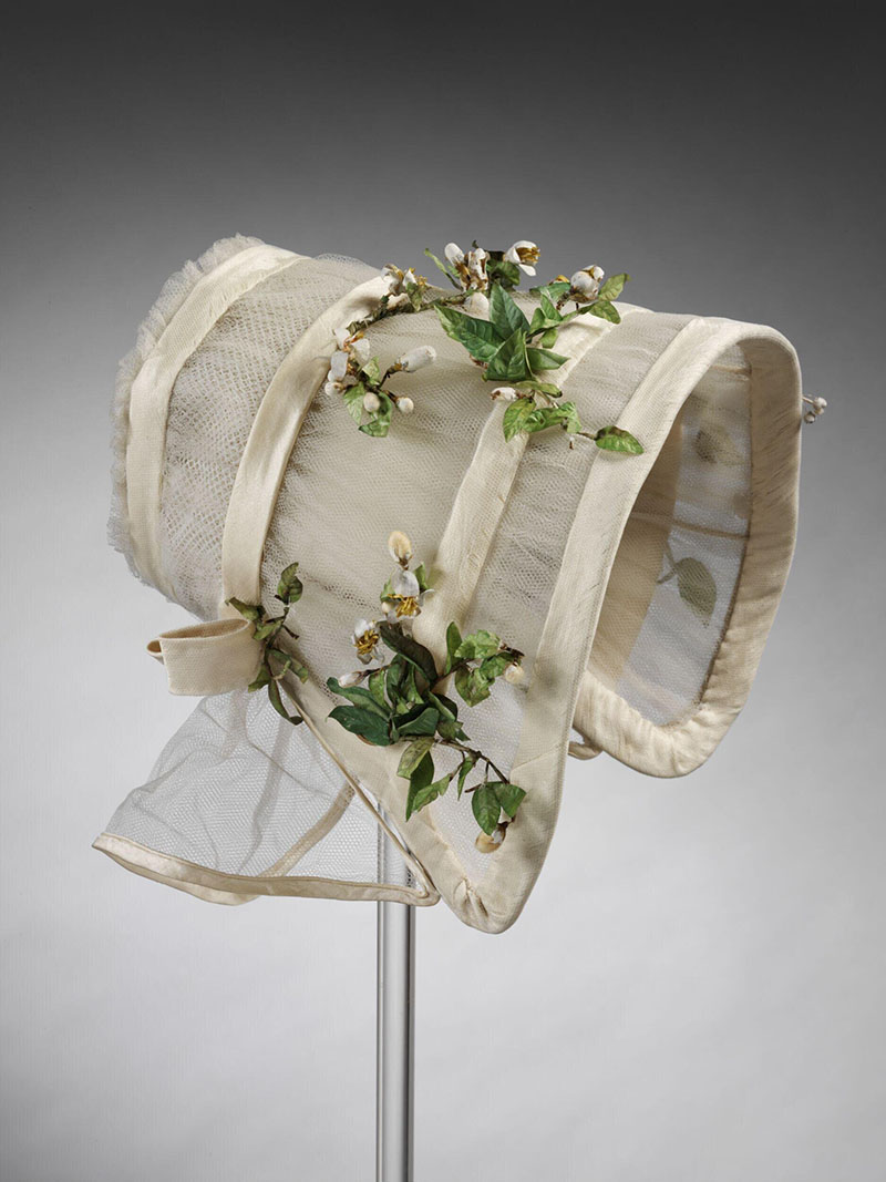 Photograph of a 19th-century white coloured wedding bonnet made up of silk tulle, crêpe, and imitation orange blossom