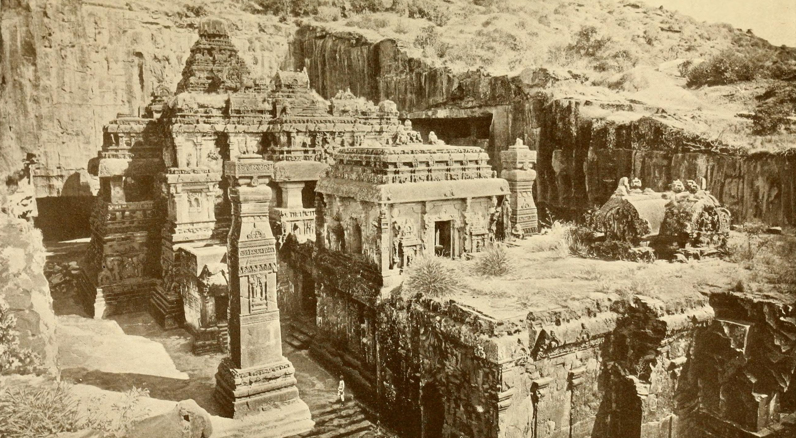 A photograph of elaborately carved rock cut structures against a cliffside.