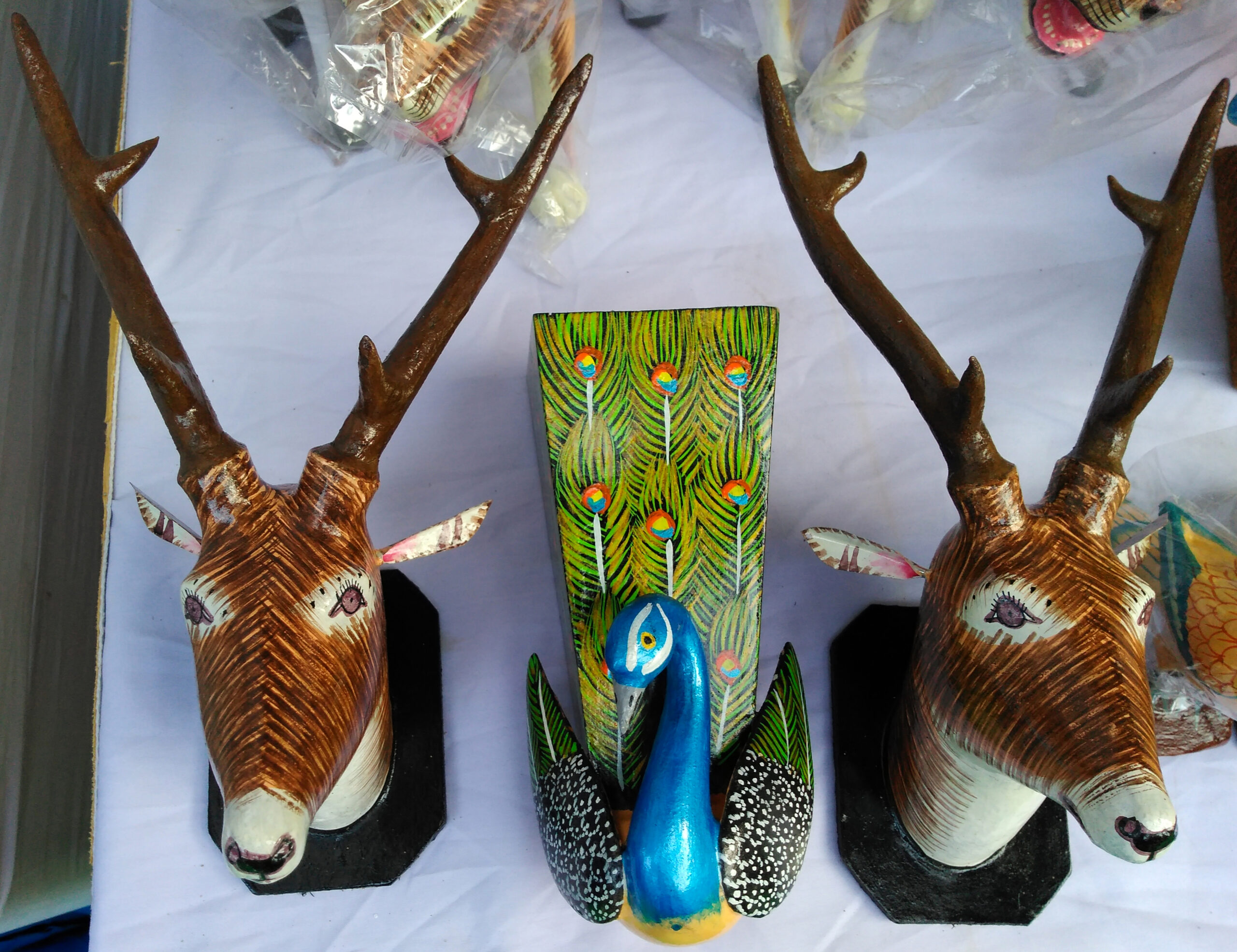 Photograph of nirmal woodwork figurines in the shape of a peacock and two deer heads