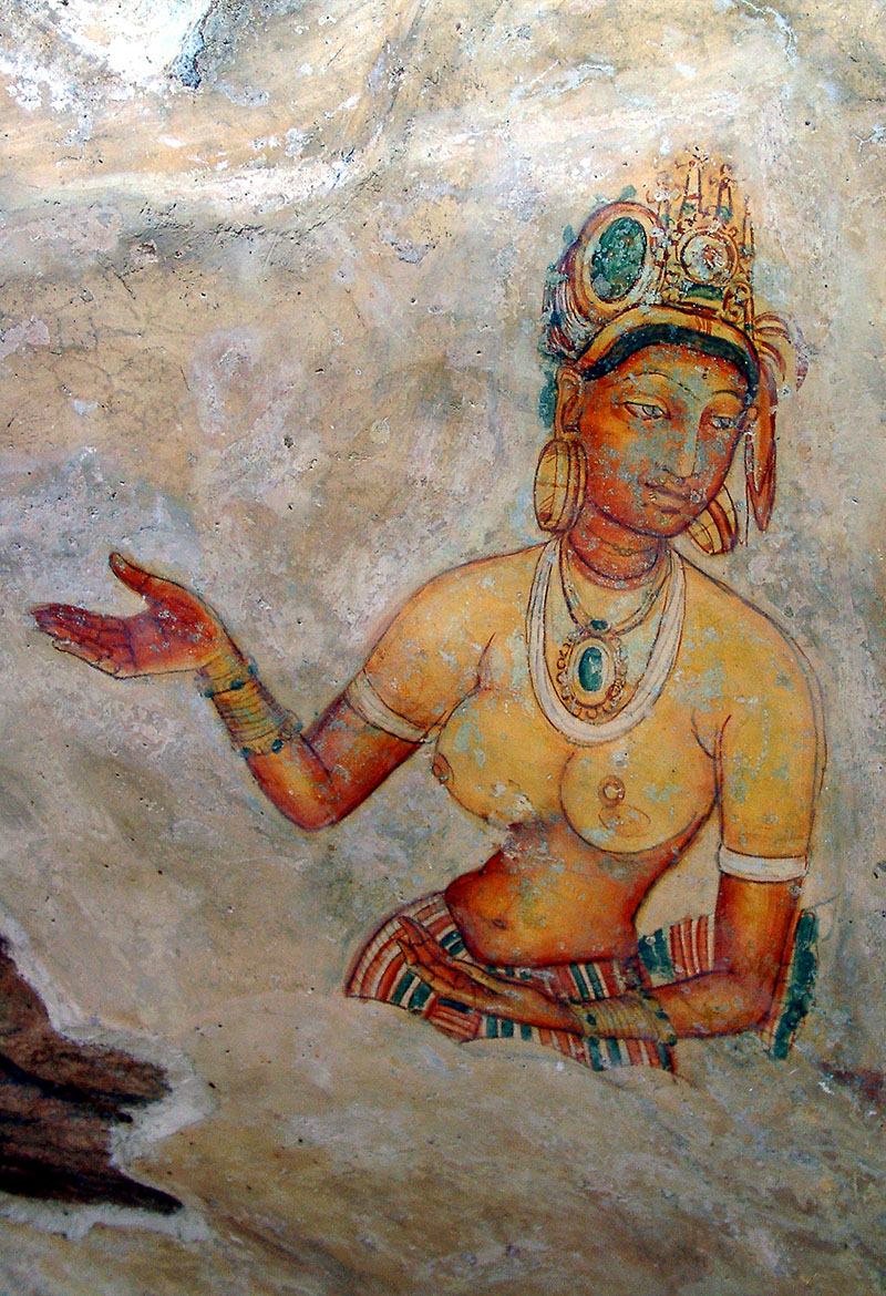 Photograph of a Sigiriya mural showing a bare-bodied, heavily bejewelled lady, with one hand raised