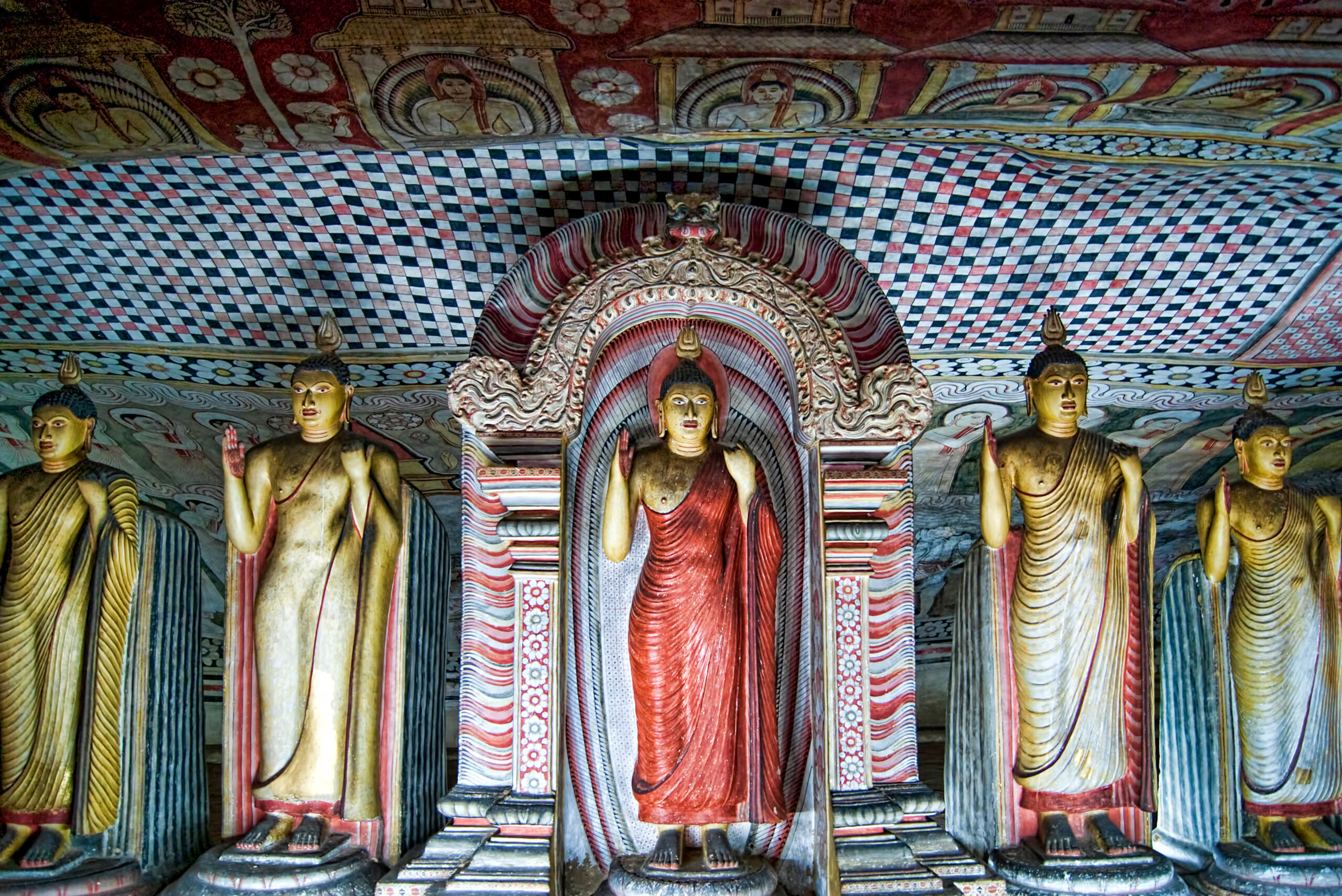 Photograph of multiple standing Buddhas inside the Dambulla Caves