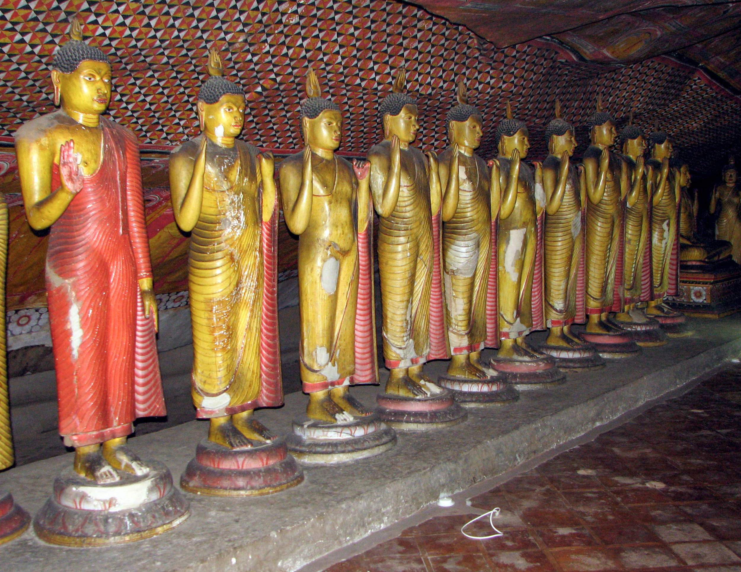 Photograph of multiple standing Buddhas inside the Dambulla Caves