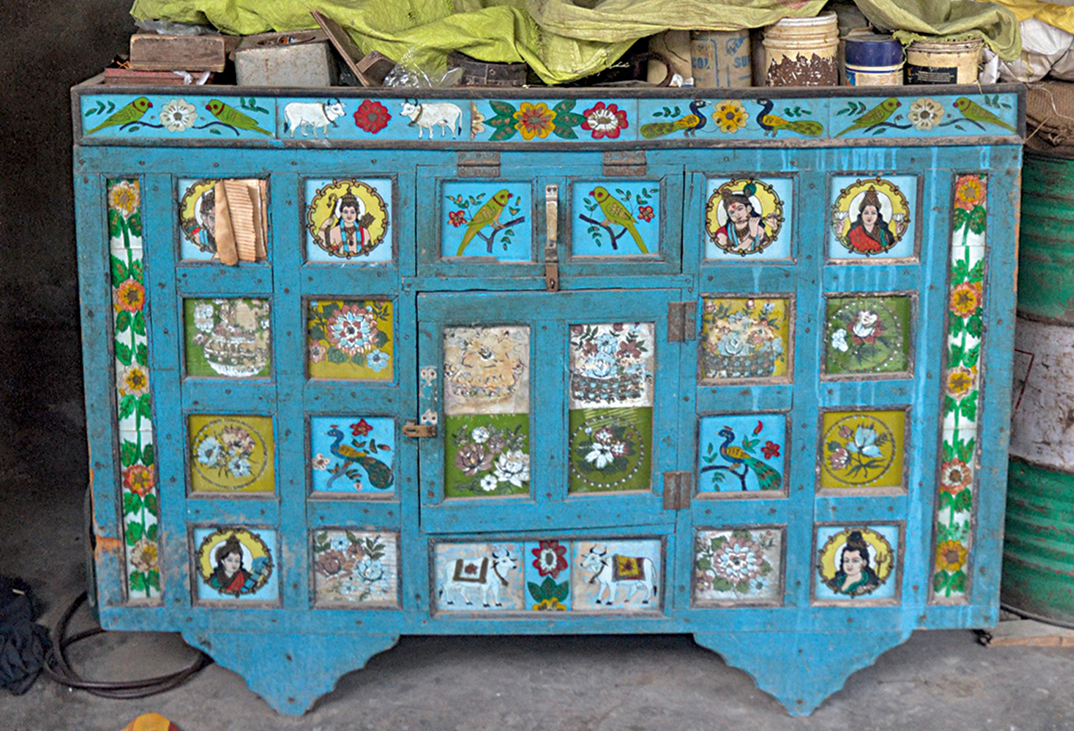Photograph of a majju with inset glass panels painted with birds, deities and floral motifs