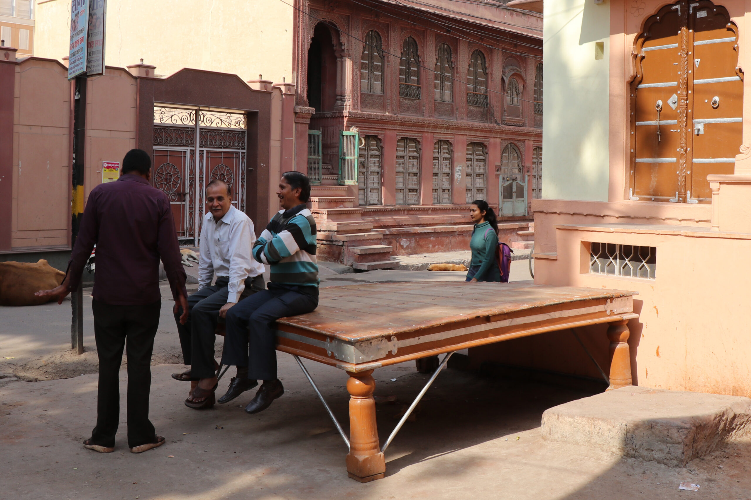 Photograph of a group of men seated on a paata placed at the Daga Sethiya Parak Guwad in Bikaner