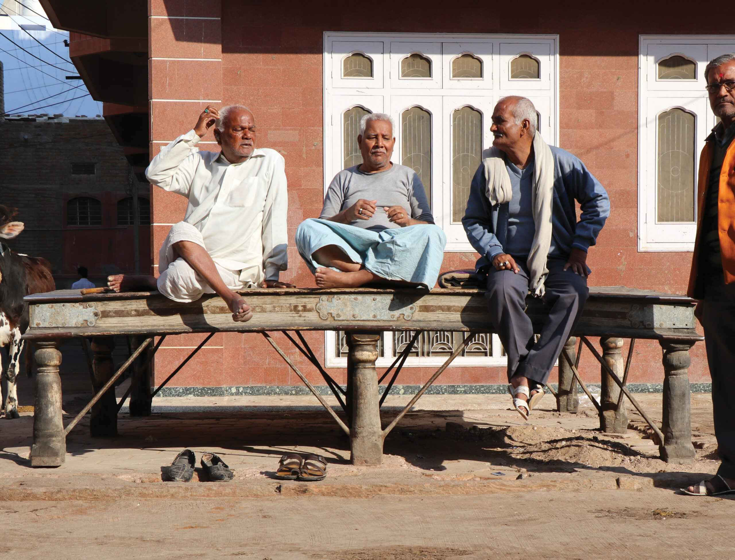 Photograph of a groupof men seated on a nine-legged paata at the Dassaniyo ka Chowk in Bikaner