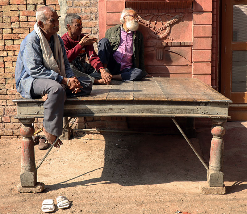 Photograph of a group of men seated on a paata placed at the Dassaniyo ka Chowk in Bikaner