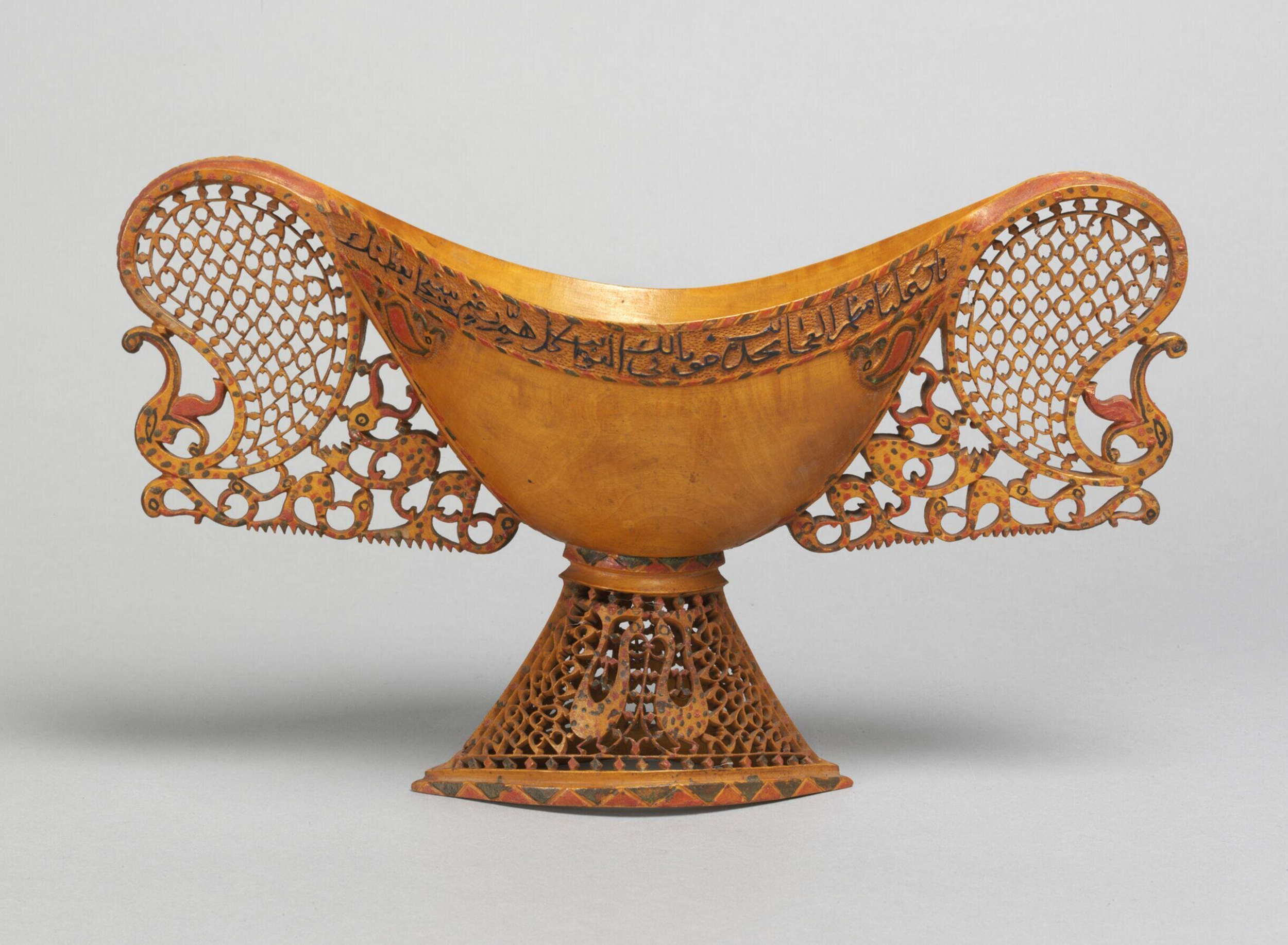 Photograph of a mid-19th century carved and painted pearwood footed kashkul from Qajar Iran