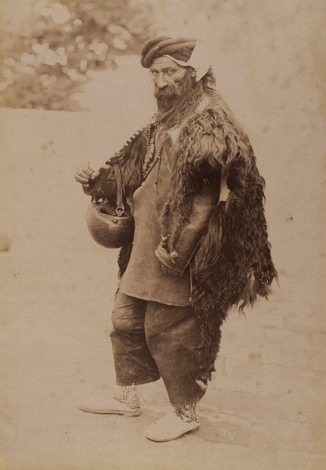 Late 19th-century archival photograph by Antoin Sevruguin of a dervish seen carrying a kashkul
