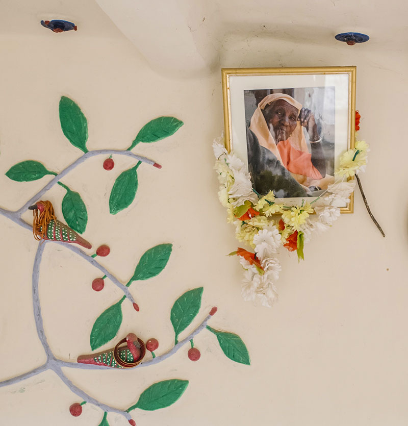 Photograph by Suleiman Merchant showing the garlanded portrait of Sonabai Rajwar inside her house