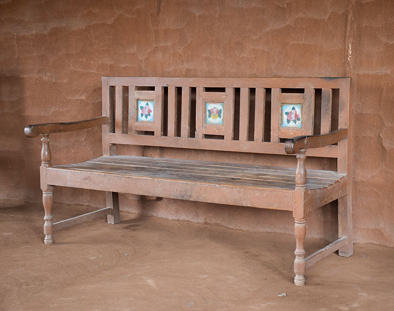 Photograph of a large wooden bench with backrest and armrests called a bannk from Tapi, Gujarat