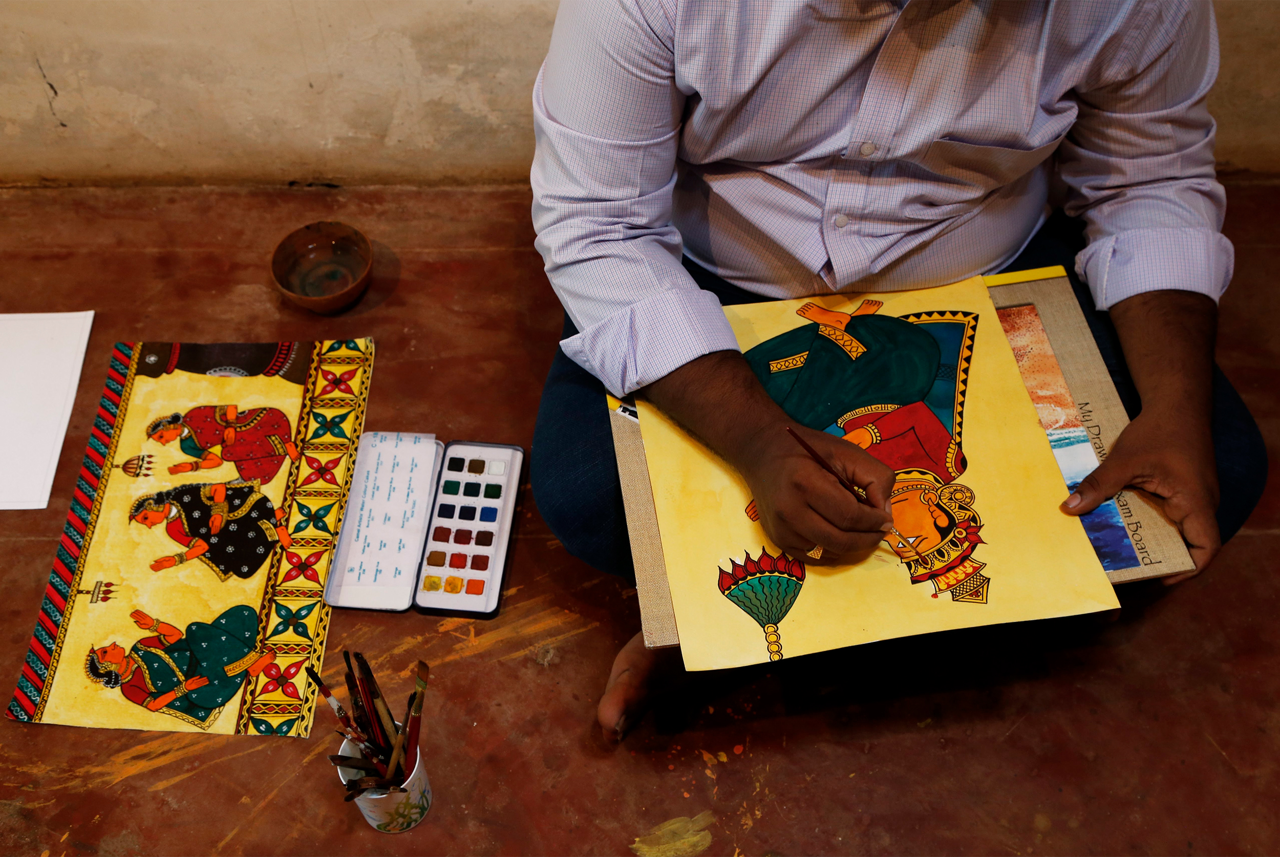 Close-up photograph of Eknath Gangawane making a chitrakathi painting